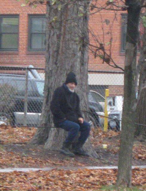 FRANK GIGLIO SITTING BENEATH A TREE IN THE DRIZZLILNG RAIN AS HIS HOUSE IS BROUGHT TO THE GROUND